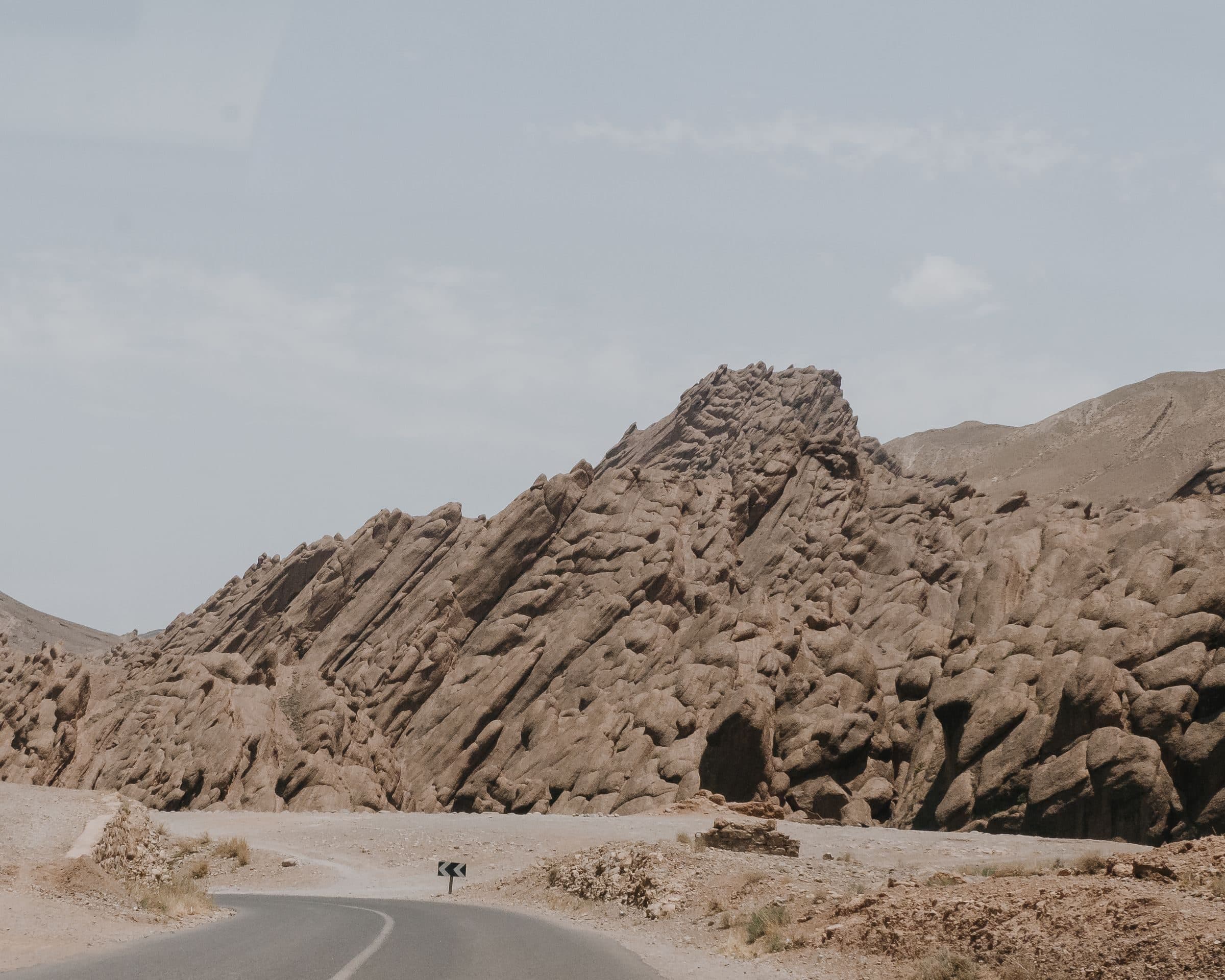 Route déserte longeant les formations rocheuses de l'Atlas marocain