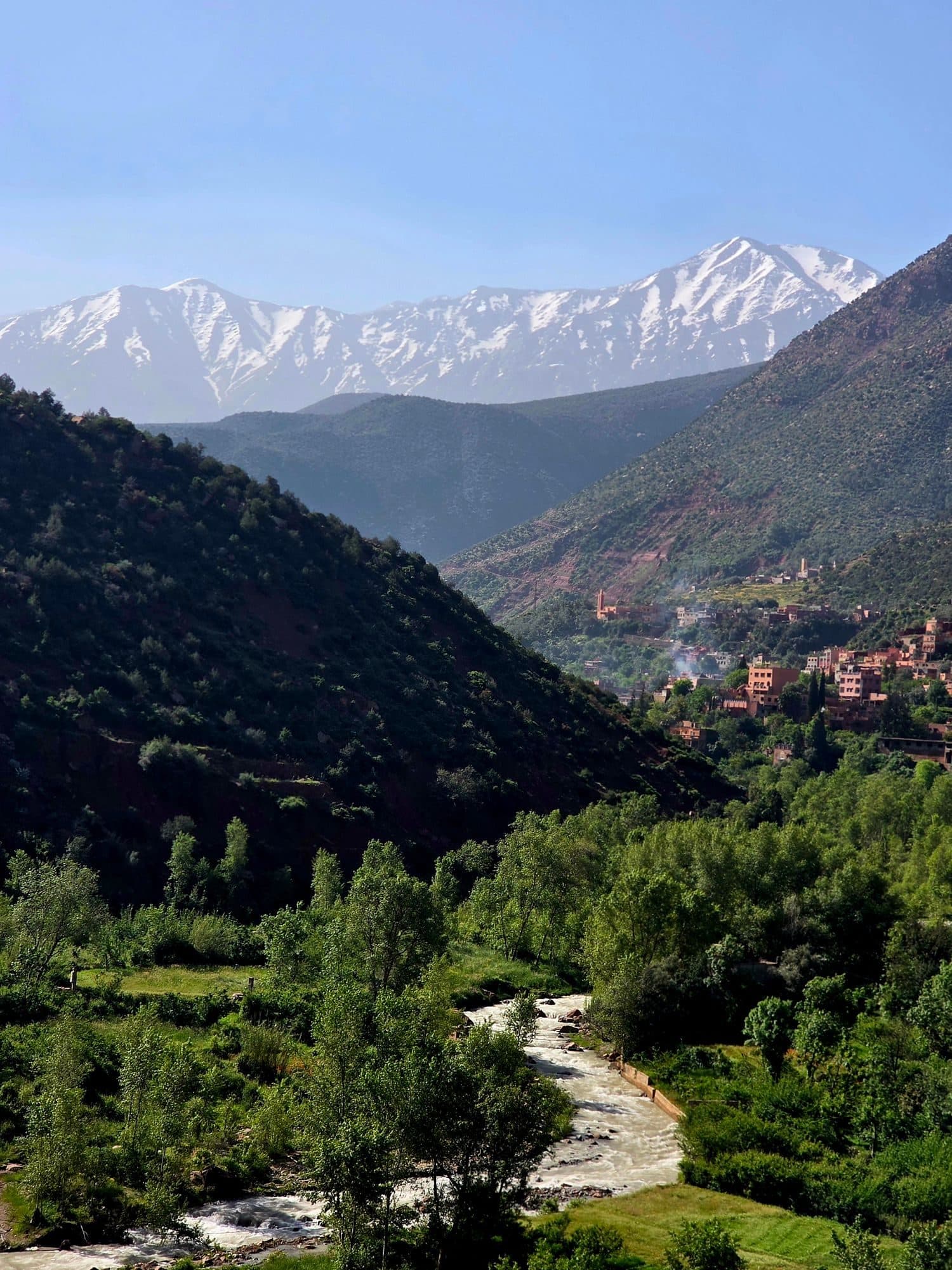 Vallée de l'Ourika verdoyante devant les sommets enneigés de l'Atlas