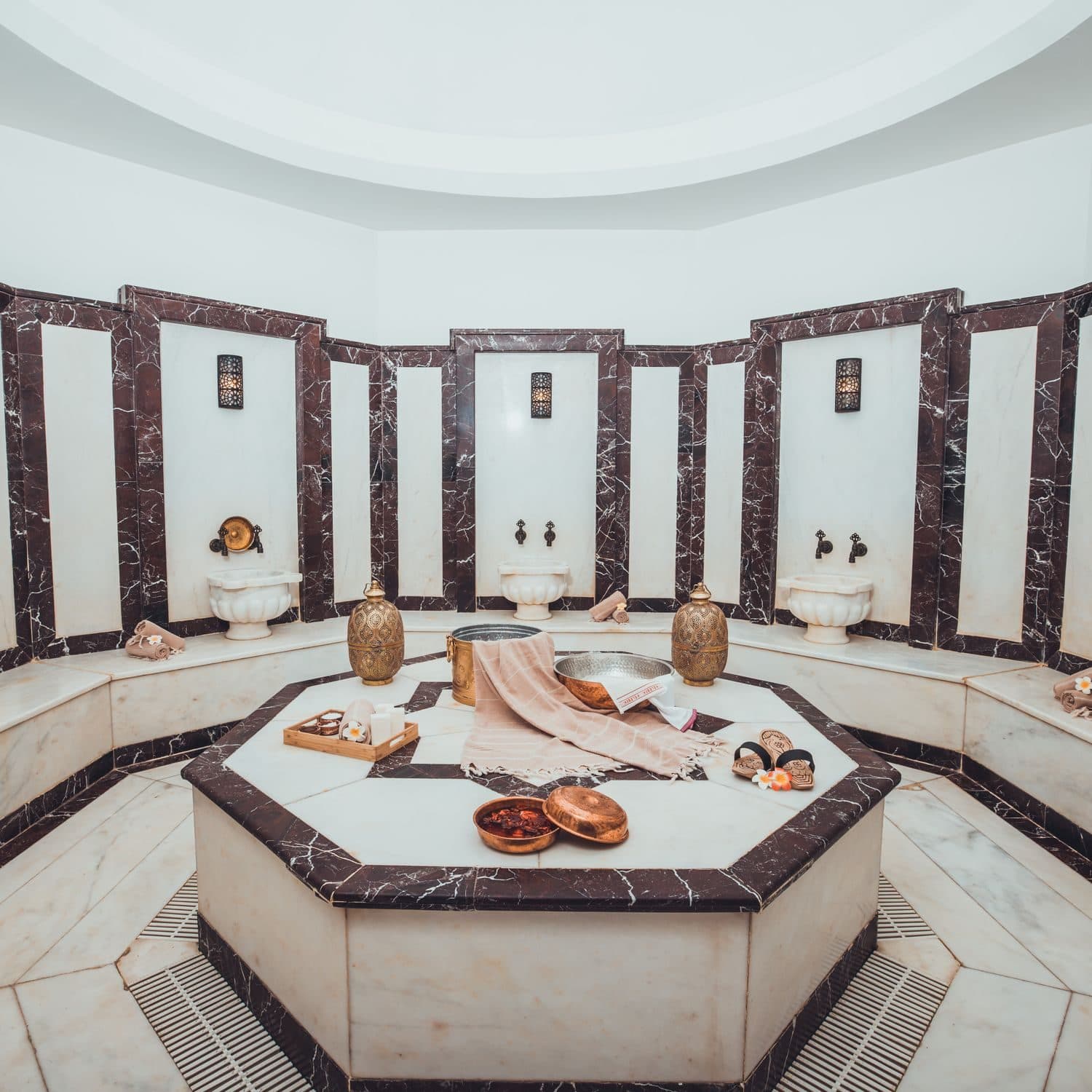 Salle de hammam en marbre, vasques et bancs traditionnels