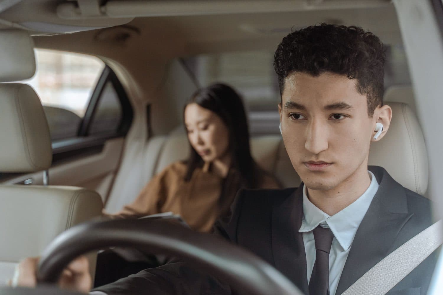 Chauffeur au volant et passagère à l'arrière, vue depuis l'habitacle